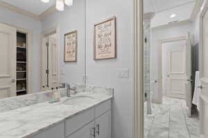 Bathroom with vanity, toilet, and ornamental molding