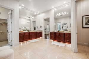 Bathroom featuring tile patterned floors, crown molding, vanity, and wood walls