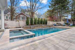 View of pool featuring an in ground hot tub and pool water feature