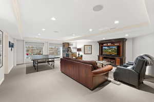 Living room with a tray ceiling and light colored carpet