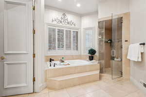 Bathroom featuring tile patterned flooring, crown molding, and independent shower and bath