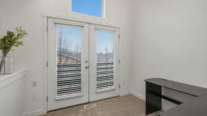 Doorway to outside with light carpet and french doors