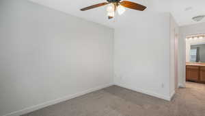 Empty room with light carpet, sink, and ceiling fan