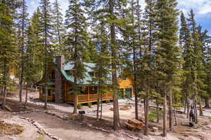 View of front of home with a wooden deck and an outdoor fire pit