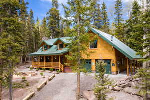 Log home featuring an outdoor fire pit, covered porch, and a garage