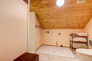 Bathroom featuring a shower, lofted ceiling, wooden ceiling, tile patterned flooring, and toilet