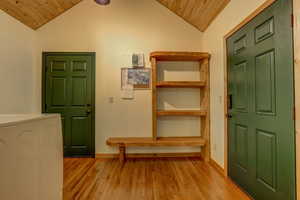 Foyer entrance with washer / clothes dryer, vaulted ceiling, and wood ceiling