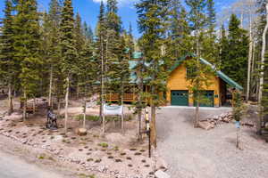 Log cabin with a garage and a wooden deck