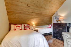 Bedroom featuring vaulted ceiling, light hardwood / wood-style flooring, and wooden ceiling