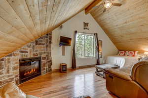 Bedroom featuring vaulted ceiling with beams, light wood-type flooring, ceiling fan, and wooden ceiling