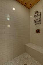 Bathroom featuring wood ceiling and tiled shower