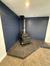 Details featuring carpet flooring and a wood stove