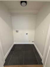 Laundry area with hookup for an electric dryer, washer hookup, hookup for a gas dryer, and dark tile patterned floors