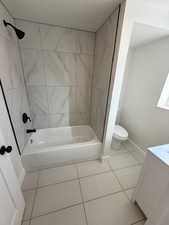 Full bathroom featuring tile patterned flooring, vanity, toilet, and tiled shower / bath combo