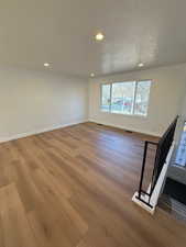 Empty room featuring a textured ceiling and light hardwood / wood-style flooring