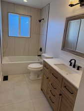 Full bathroom featuring tile patterned flooring, vanity, toilet, and tiled shower / bath