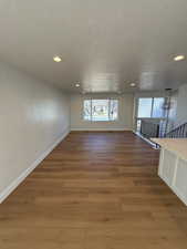 Unfurnished room with hardwood / wood-style floors and a textured ceiling