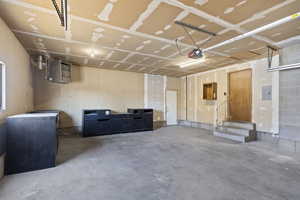 Garage featuring electric panel and a garage door opener