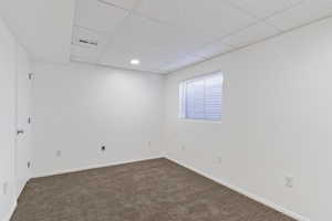 Unfurnished room featuring carpet flooring and a drop ceiling