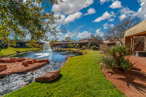 View of yard and stream flowing into pond