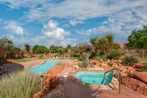 View of swimming pool with an in ground hot tub and a patio