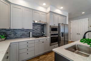 Kitchen featuring sink, stainless steel appliances, Quartz counters, and tile  backsplash