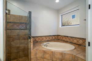 Bathroom featuring tile shower and jetted tub