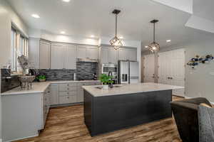 Updated Kitchen with pendant lighting, quartz countertops, and stainless steel appliances