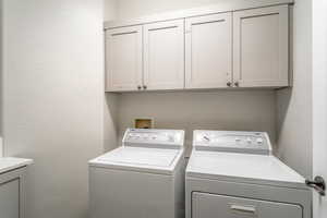 Laundry room with washer and dryer and cabinets