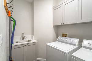 Laundry room with cabinets, sink, and washer and dryer