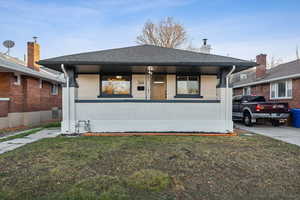 View of front of house with a front yard and a porch