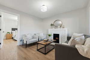 Living room featuring light hardwood / wood-style flooring and a brick fireplace