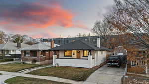 View of front of property with a lawn, a mountain view, and a porch