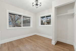 Unfurnished dining area with hardwood / wood-style flooring and a notable chandelier