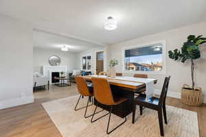 Dining space with a fireplace and light hardwood / wood-style flooring