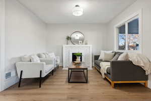 Living room featuring a brick fireplace and light hardwood / wood-style flooring