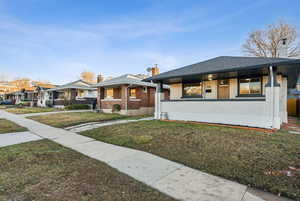 View of front of property featuring a porch and a front yard