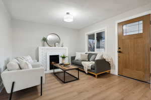 Living room with a fireplace and light hardwood / wood-style floors