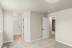 Unfurnished bedroom featuring light colored carpet