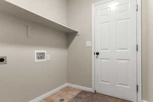 Laundry room featuring electric dryer hookup, tile patterned flooring, and washer hookup