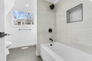 Second bathroom with tile patterned floors, and tiled shower / bath combo