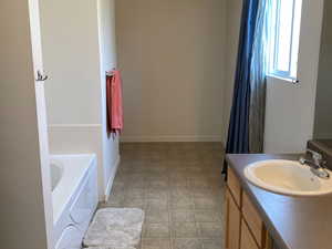 Bathroom featuring tile patterned floors, a tub, and vanity