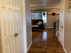 Hallway with dark hardwood / wood-style floors and ornamental molding