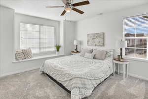 Bedroom with multiple windows, ceiling fan, and carpet