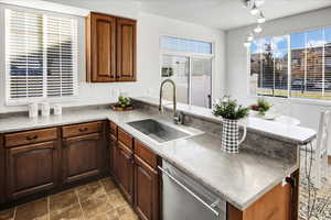 Kitchen with kitchen peninsula, stainless steel dishwasher, and sink