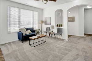 Living room featuring light colored carpet and ceiling fan