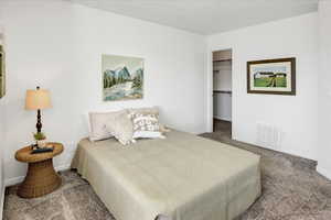 Bedroom with carpet flooring and a spacious closet.