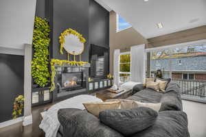 Living room with hardwood / wood-style floors and a towering ceiling