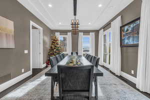 Dining space with a notable chandelier and dark wood-type flooring