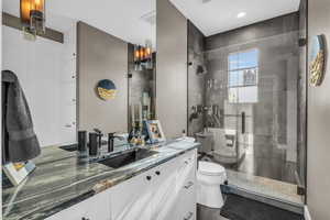 Bathroom with vanity, toilet, and an enclosed shower